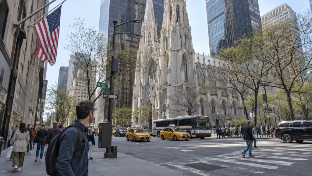 Fifth Avenue near Rockefeller Center with St. Patrick's Cathedral, taxis, and pedestrians.