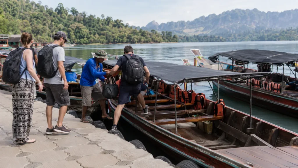 Travelers boarding a longtail boat at Ratchaprapha Pier